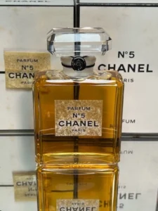 Frasco vintage do perfume Chanel Nº5 sobre uma superfície, representando perfume como identidade no século XX.